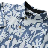 Camisa de manga corta color celeste con estampado orgánico abstracto en color blanco, con cierre frontal de botones y un bolsillo en el pecho. Elaborada en una mezcla de algodón orgánico y tencel.