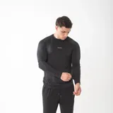 Remera de compresión manga larga color negro, con ajuste al cuerpo y logo de la marca Gains estampado en el pecho. Confeccionada en tejido técnico elástico y transpirable.