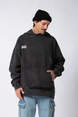 Buzo tipo canguro con capucha, de corte oversize y confeccionado en frisa rústica con efecto lavado. Presenta bolsillo frontal tipo canguro y estampado con texto en el pecho.