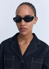 Chaqueta de denim azul oscuro con cuello solapa, cierre frontal de botones y dos bolsillos de parche en el pecho.