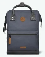 Mochila de diseño urbano en color azul marino, con detalles en cuero sintético marrón y negro. Cuenta con compartimento principal con cierre, bolsillo frontal con cierre, asas superiores reforzadas y base reforzada.