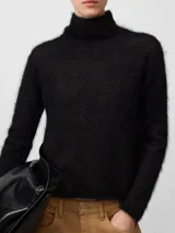 Sweater de punto cardado con textura suave y esponjosa, cuello chimenea y manga larga. Presenta un diseño minimalista y elegante con etiqueta logotipada en la espalda.