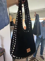 Bolso negro de gamuza con tachas plateadas.