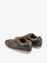 Zapatilla de estilo urbano con diseño de silueta clásica, confeccionada en cuero con textura de pelo natural y estampado animal print. Presenta cierre con cordones, refuerzo en el talón y suela dentada.