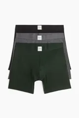 Pack de tres calzoncillos tipo trunk (boxer ajustado a media pierna) con cintura elástica. Incluye uno verde oscuro, uno gris jaspeado y uno negro.