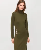Vestido largo verde militar de punto, con cuello alto, manga larga y detalle de hebilla metálica en la cadera.