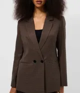 Blazer sastrero de corte alargado con estampado de cuadros pequeños en tonos marrones. Presenta cuello con solapa, cierre frontal con dos botones y mangas largas.