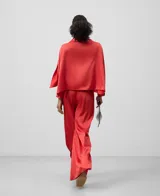 Pantalón de poliéster reciclado color rojo, de pierna ancha y con cierre de cremallera lateral.