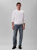 Buzo de Calvin Klein color blanco, confeccionado en algodón regenerado, con cuello redondo, puños y dobladillo de punto canalé y un mini monograma en parche en el pecho.