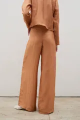 Pantalón tipo palazzo de corte recto y holgado, confeccionado en tela con textura arrugada y acabado satinado, con cierre invisible en la parte trasera.