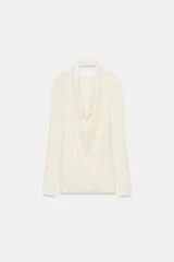 Camiseta de manga larga color crudo con cuello redondo y detalle de top halter superpuesto en el mismo tejido. Presenta un diseño de doble capa con caída drapeada en el frente.