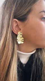 Aros colgantes dorados con forma irregular y textura ondulada.