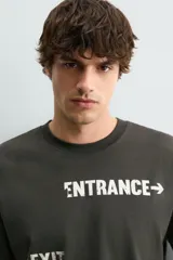 Camiseta de algodón con corte relajado, cuello redondo y manga corta. Presenta estampados gráficos a contraste en el frente con inscripciones tipo señalética.