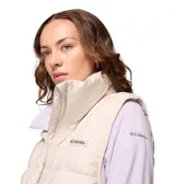 Chaleco acolchado Columbia modelo Pike Lake III, color beige, con tecnología Omni-Heat reflectante y aislamiento sintético reciclado. Presenta cierre frontal bidireccional, cuello alto con protección para la barbilla y bolsillos laterales con cierre.