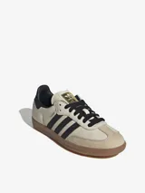 Zapatillas Adidas Samba OG de cuero color crema con detalles en negro y suela de goma marrón.
