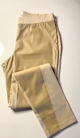 Pantalón combinado tostado, confeccionado con un panel frontal de cuerina elástica en tono camel y un panel posterior de gabardina con spandex en tono tostado. Presenta una cintura elastizada para mayor comodidad y costuras a la vista en contraste.