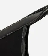 Cartera shopper grande de color negro, confeccionada en poliéster con detalles en material sintético en las esquinas inferiores y en las asas integradas. Cuenta con costuras pespunteadas a contratono y una estructura amplia con abertura superior con cierre.