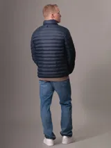 Campera inflada Calvin Klein color azul marino, con cuello alto, cierre frontal con cremallera, bolsillos laterales y logo de la marca en el pecho.