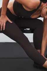 Calza deportiva de tiro alto color marrón, con diseño de perforaciones láser en la parte inferior de las piernas.