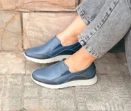 Zapatos tipo pancha sin cordones, fabricados en cuero azul marino con detalles texturizados y suela blanca de poliuretano.