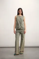 Chaleco azul de denim con cuello en V y cierre frontal con botones metálicos. Posee bolsillos delanteros y corte clásico.