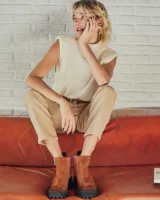 Botines negros de cuero con textura de reptil, paneles laterales de gamuza, cierre lateral con cremallera y suela track.