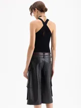 Top tejido de punto acanalado en color negro, con cuello redondo y diseño ajustado al cuerpo. Presenta un corte sin mangas con estilo deportivo y espalda con breteles cruzados.