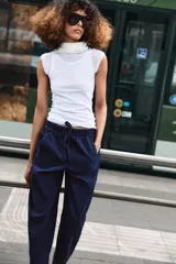 Pantalón de tiro bajo con cintura elástica ajustable mediante cordón, bolsillos delanteros y bolsillos de plastrón en la parte trasera.