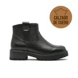 Bota corta de cuero negro con suela track dentada y taco bajo. Presenta un diseño minimalista con costuras reforzadas y un detalle metálico en la parte superior del lateral.