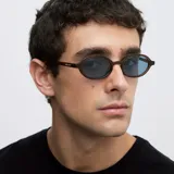 Lentes de sol con montura ovalada de color mostaza y cristales celestes polarizados.