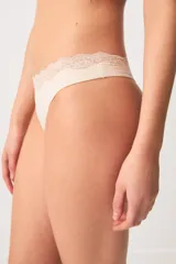 Bombacha colaless color beige, confeccionada en modal con detalles de encaje floral en la cintura.