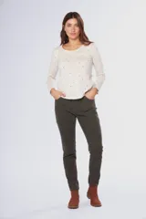 Pantalón de pana elastizada color negro, corte ajustado, cinco bolsillos y accesorios metálicos personalizados.