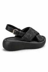 Sandalias de plataforma color negro, con tiras cruzadas de tela estampada en blanco y negro, tira trasera ajustable con hebilla metálica y suela chunky de goma.