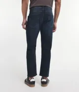 Pantalón de jean azul oscuro, corte slim, con trabillas en la cintura y bolsillos.