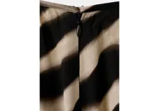 Pantalón largo de viscosa con estampado animal print tipo cebra en tonos beige y negro, de corte recto y holgado.