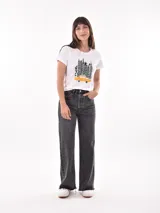 Remera negra de algodón con estampado frontal de la palabra "MERCI" en letras delineadas con colores del arcoíris.