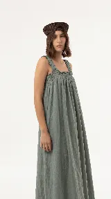 Vestido largo de lino color marrón, de silueta amplia y caída liviana, con escote cuadrado, frunces elastizados en el pecho y breteles anchos con detalles de volados.