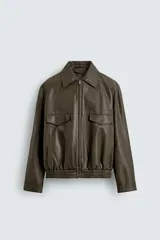 Cazadora tipo bomber de corte relajado confeccionada en tejido efecto piel color verde oscuro. Presenta cuello solapa, cierre frontal con cremallera, bolsillos de plastrón con solapa en el pecho, bolsillos ocultos en la cadera y bajo con elástico.