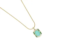 Collar de cadena fina con baño de oro y dije ovalado con piedra central color turquesa, rodeada por un marco de circonias blancas y pequeñas piedras verdes.