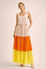 Falda midi de corte amplio con diseño de tres niveles en bloques de color: beige, naranja y amarillo. Presenta cintura elástica con cordón ajustable y bolsillos laterales.