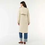 Trench midi color beige con cuello camisero, cierre frontal de botones y bolsillos laterales. Diseño clásico de gabardina con solapas y estructura fluida.