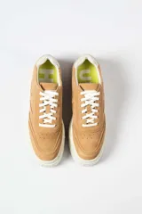 Zapatilla de gamuza color tostado con plataforma alta de goma blanca y cordones al tono.
