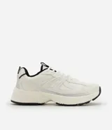 Championes de estilo jogging marca Satinato, confeccionados en poliuretano y poliéster. Presentan un diseño en color blanco con detalles en negro y gris, cierre por cordones, lengüeta y cuello acolchados, y una suela robusta.
