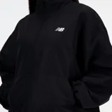 Campera deportiva New Balance negra, de corte holgado, con cierre frontal, cuello alto y mangas largas con puños elásticos. Logo de la marca estampado en blanco en el pecho.