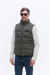 Chaleco puffer de nylon con diseño matelaseado, cuello alto y cierre frontal. Cuenta con bolsillos laterales y un pequeño parche con logo en el pecho.