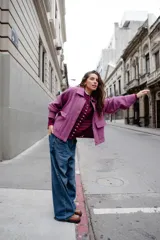 Chaqueta de lana afieltrada en color amarillo mostaza, con cuello camisero, cierre frontal con broches a presión y bolsillos delanteros. Presenta un diseño de espalda con apertura para mayor movimiento.