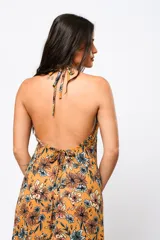 Vestido largo color ocre con estampado floral, escote en V y espalda descubierta.