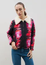 Campera con estampado de bosque en tonos azules, cuello de sherpa en color crema y cierre frontal con cremallera. Cuenta con elástico ajustable en la cintura.