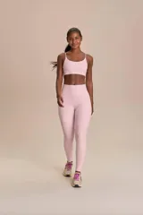 Conjunto deportivo de dos piezas en color rosado, compuesto por una calza larga de tiro alto y un top corto de tirantes finos.