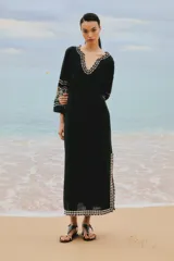 Túnica larga negra de terciopelo con bordados dorados en escote, mangas y ruedo.